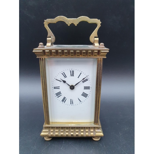 62 - A late 19th century brass cased Carriage Clock with lever escapement, white enamel dial, swing handl... 