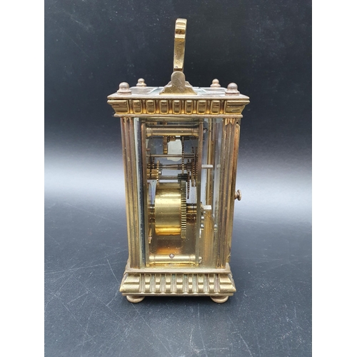 62 - A late 19th century brass cased Carriage Clock with lever escapement, white enamel dial, swing handl... 
