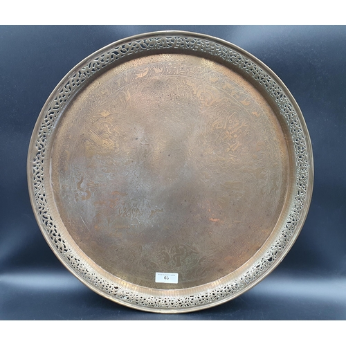 63 - An Indian brass circular Tray engraved figures and animals, pierced border, 21in