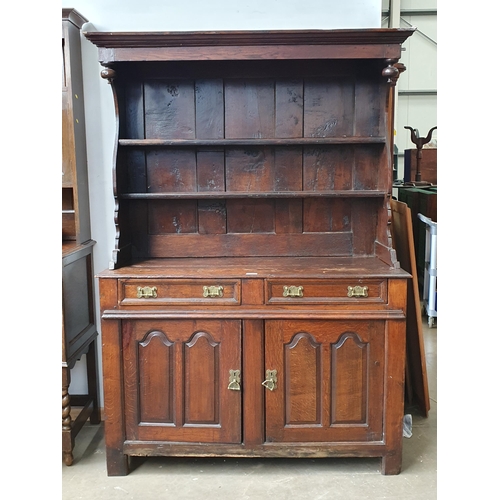 74 - An early 18th Century oak canopy Dresser fitted boarded shelves above two drawers and a pair of door... 