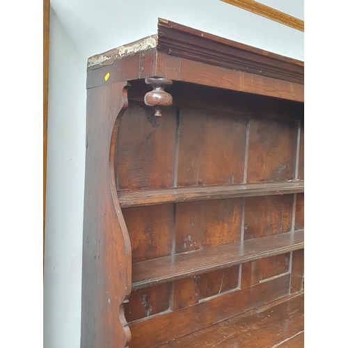 74 - An early 18th Century oak canopy Dresser fitted boarded shelves above two drawers and a pair of door... 