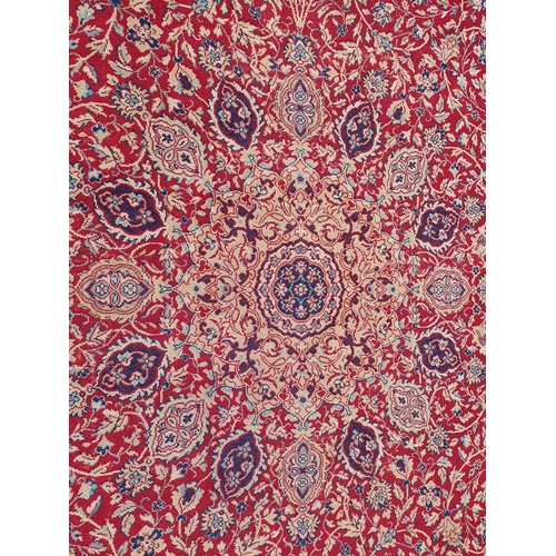 832 - A red ground Persian style Carpet, with multiple floral borders, with large central motif surrounded... 