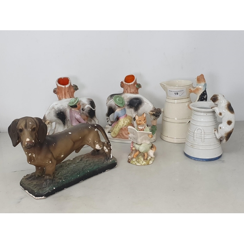 19 - A plaster Model of a Dachshund, a pair of Staffordshire Dairy Girl and Cow Vases, two antique Jugs w... 