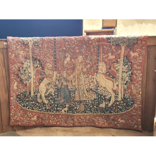 225 - A Tapestry/Wall Hanging with design of female figures, lion and a unicorn in a floral wooded landsca... 