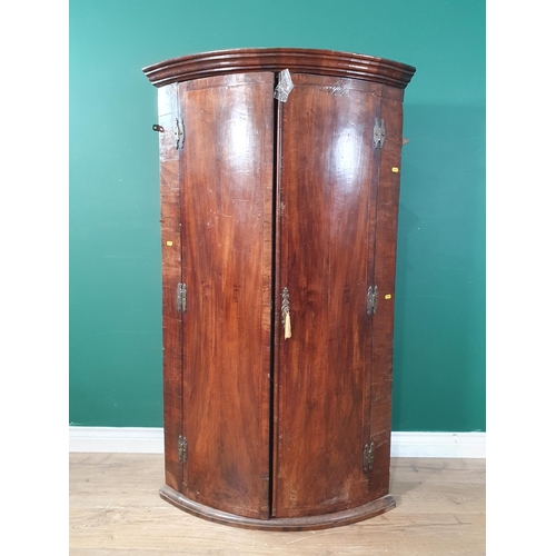 26 - An antique bow fronted Hanging Corner Cupboard, the pair of doors enclosing three fitted shelves, A/... 