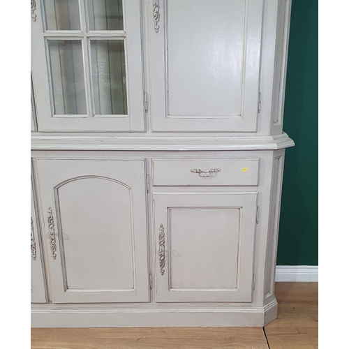 28 - A large grey painted continental Cupboard, the top section with shaped cornice above pair of glazed ... 
