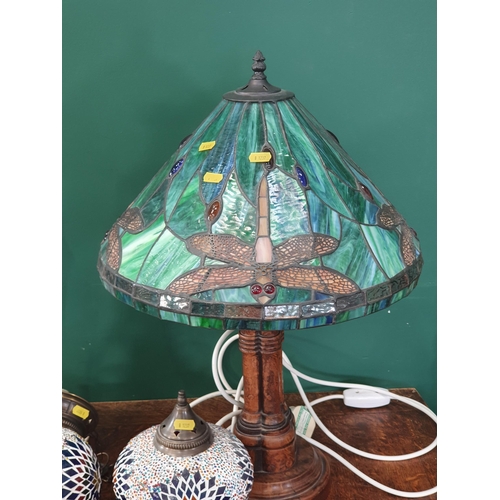 290 - A Tiffany Style Table Lamp the coloured glass shade with dragonfly designs, raised on turned wooden ... 