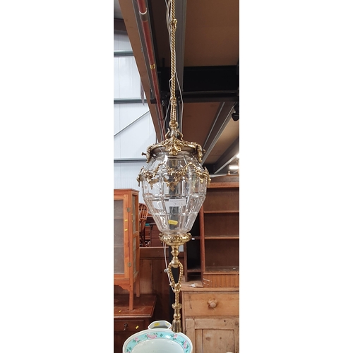 301A - A gilt metal Hanging Ceiling Light with rope twist and floral designs, having a panelled cut glass b... 