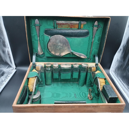 146 - A George V leather Vanity Case containing numerous silver mounted fittings including brushes and mir... 