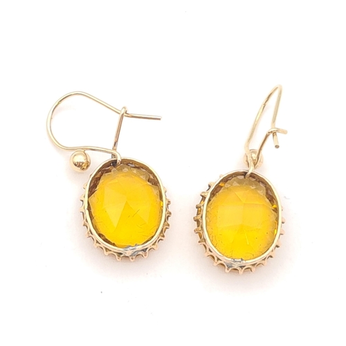 155 - A pair of yellow paste Drop Earrings each claw-set oval-cut stone on wire fittings, unmarked, untest... 