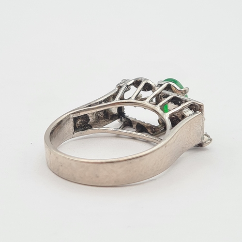 157 - A Jade and Diamond Ring claw-set oval jade between trios of eight-cut diamonds in white metal, stamp... 