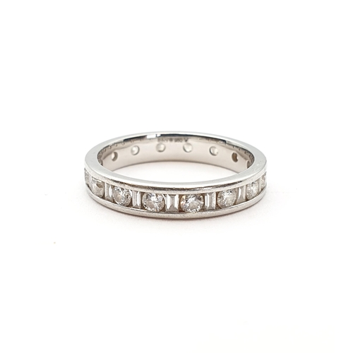 176 - A Diamond Eternity Ring channel-set alternating baguette and brilliant-cut stones in platinum, ring ... 