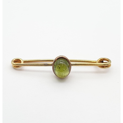 184 - A gold Bar Brooch set green oval cabochon, marked 15ct, approx 5cms long, approx 4.9gms