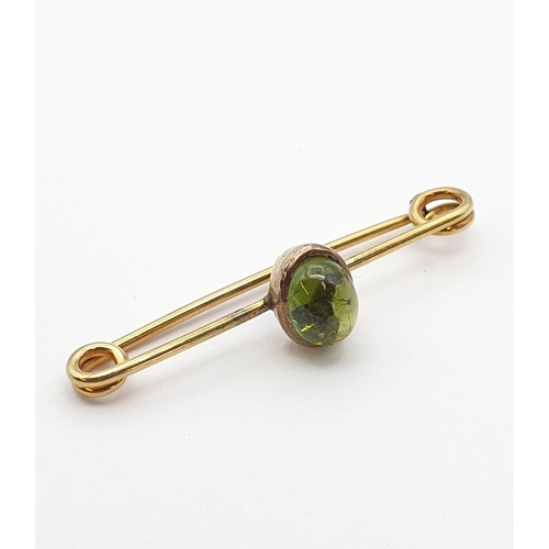 184 - A gold Bar Brooch set green oval cabochon, marked 15ct, approx 5cms long, approx 4.9gms