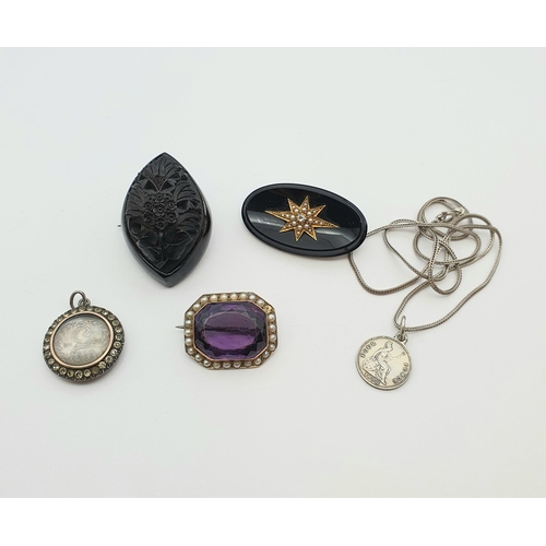 185 - An Amethyst and Seed Pearl Brooch set step-cut amethyst within an frame of seed pearls, a carved jet... 