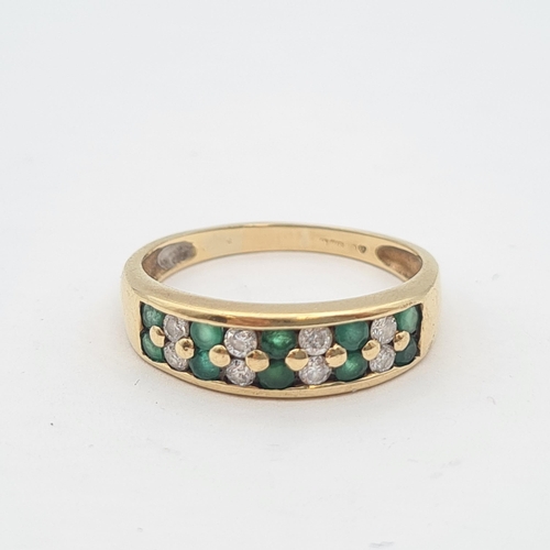 205 - An Emerald and Diamond half Eternity Ring peg and channel-set round emeralds alternating with brilli... 