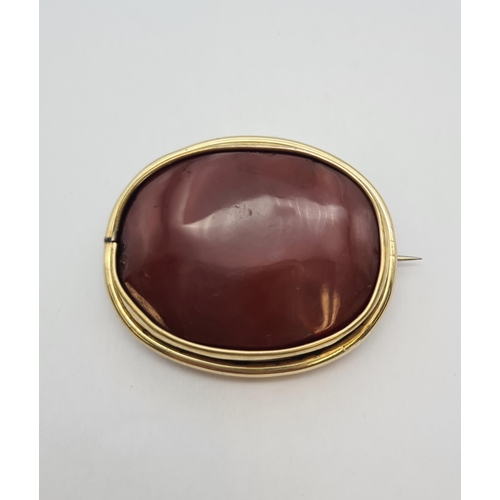 223 - An oval Brooch set carnelian in yellow metal frame