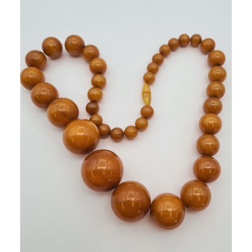 226 - A graduated string of butterscotch coloured Bakelite Beads, approx 52cms long, approx 95gms