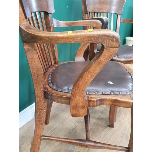 10 - A near pair of 1920's beech framed Office Elbow Chairs with leather style brown upholstered seats, o... 