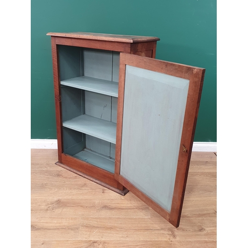 11 - An Arts & Crafts walnut Cupboard with carved floral decorated panelled door enclosing fitted shelves... 