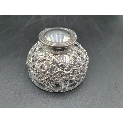 133 - An Edward VII silver lidded and mounted circular glass Inkwell with pierced and scroll embossing, Bi... 