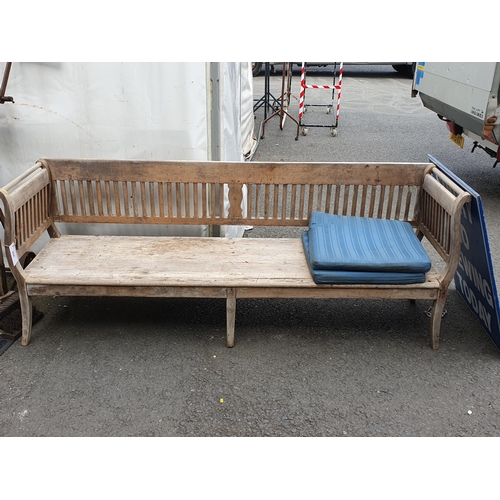 254 - A Continental pine Four Seater Bench with spindle and shaped splat back, shaped arms with solid seat... 