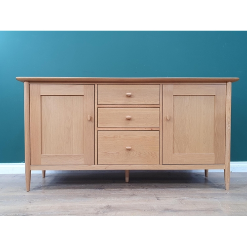 38 - A modern light oak Sideboard fitted three drawers flanked by a pair of cupboard doors, 5ft 2in W x 2... 