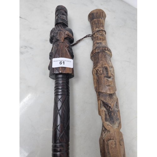 61 - Two African Tribal Walking Sticks carved figures, one holding an object, approx 3ft (R3)