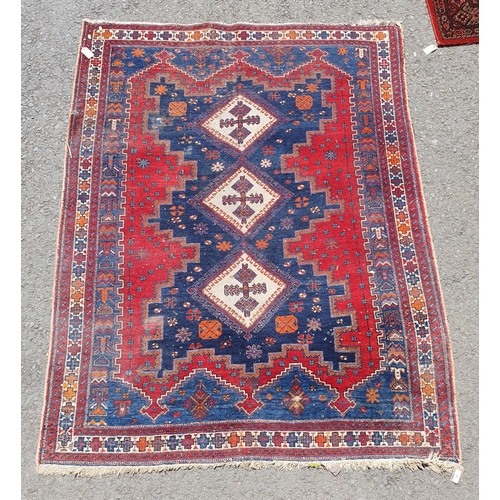 767 - A Multi bordered blue ground rug with three central lozenges and geometric designs 6ft 9