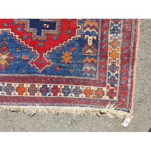 767 - A Multi bordered blue ground rug with three central lozenges and geometric designs 6ft 9