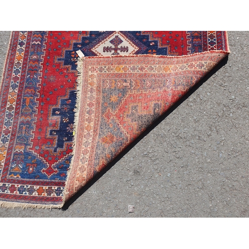 767 - A Multi bordered blue ground rug with three central lozenges and geometric designs 6ft 9