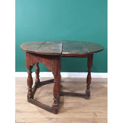 341 - An early 18th century oak Credence Table, the fold over demi-lune top above a shaped frieze and draw... 