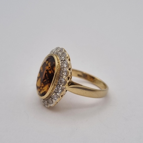 170 - A Madeira Citrine and Diamond Cluster Ring rubover-set oval mixed-cut citrine within a frame of pavé... 