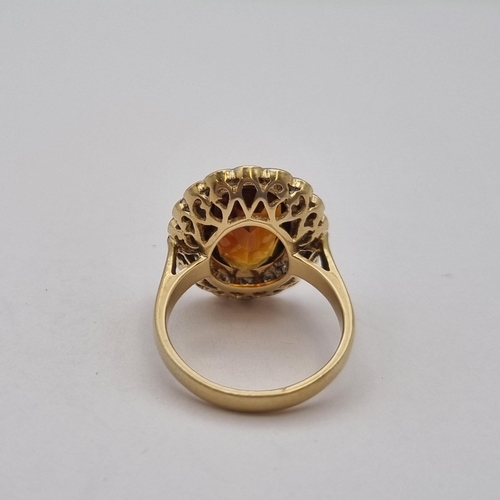 170 - A Madeira Citrine and Diamond Cluster Ring rubover-set oval mixed-cut citrine within a frame of pavé... 