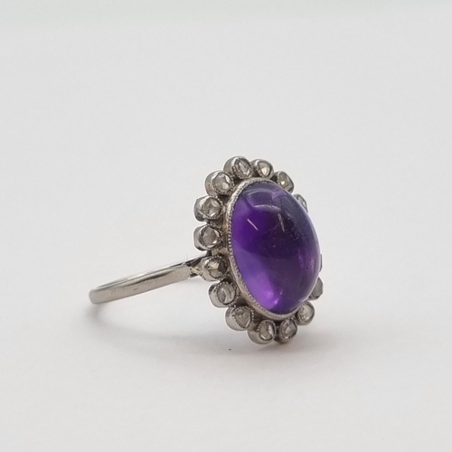 188 - *****WITHDRAWN*****

An Amethyst and Diamond Cluster Ring millegrain-set oval amethyst cabochon with... 