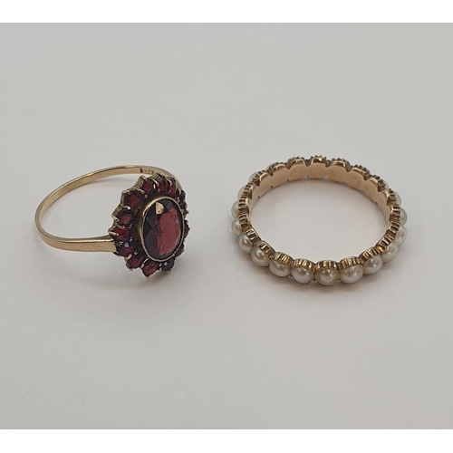 202 - A Garnet Cluster Ring set oval-cut stone within smaller round stones in 9ct gold, ring size O 1/2, a... 