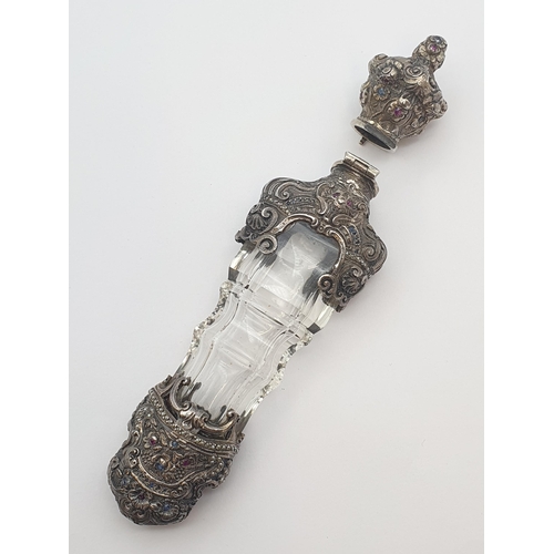 206 - A 19th Century cut glass Scent Bottle with intricate silver mounts set rubies, sapphires and seed pe... 