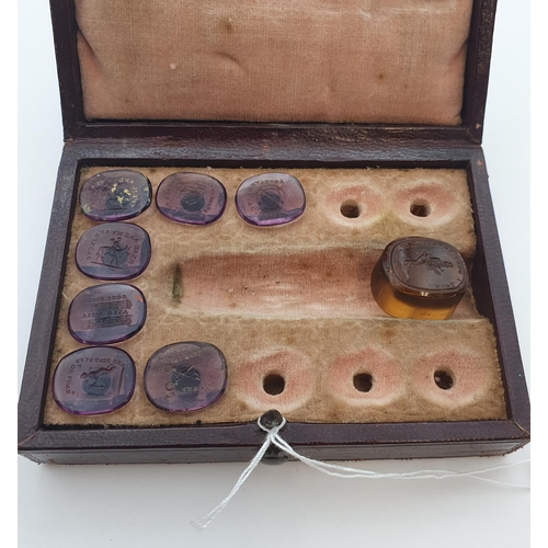 211 - A case containing seven amethyst glass Intaglio Seals, and another in amber glass 'Hope I Don't Intr... 