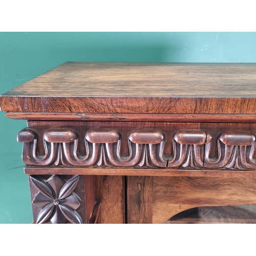 289 - A 19th Century rosewood Display Cabinet with carved frieze above a single glazed door enclosing thre... 