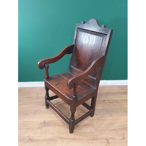 299 - A 17th Century Wainscot Elbow Chair with arched cresting to the fielded panelled back, scrolled arm ... 