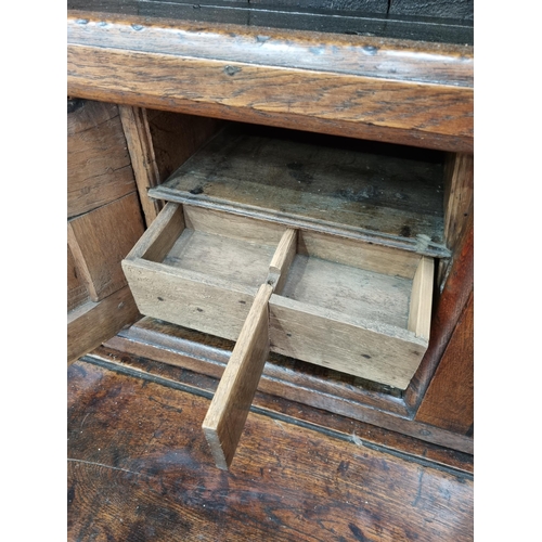 365 - An 18th Century oak enclosed Dresser with rack fitted three fielded panel doors above base fitted tw... 