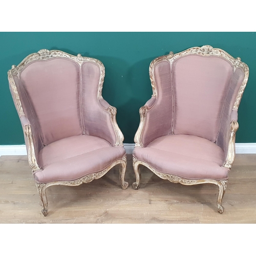 373 - A pair of French gilt and upholstered Wingback Armchairs with carved decoration, raised on squat scr... 