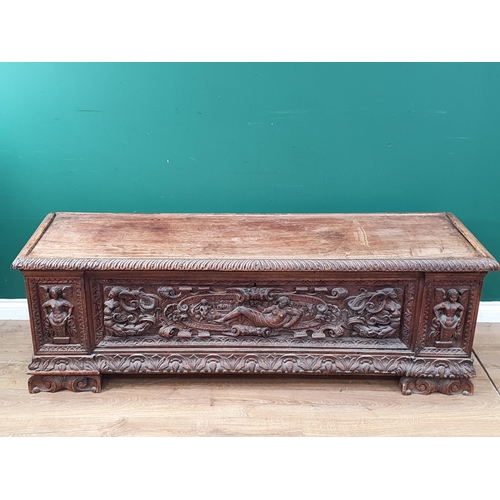 379 - An early walnut Italian Cassone with hinged cover the front relief carved with mythical figures, che... 