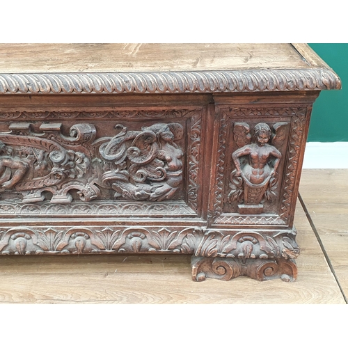 379 - An early walnut Italian Cassone with hinged cover the front relief carved with mythical figures, che... 