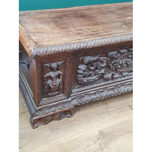 379 - An early walnut Italian Cassone with hinged cover the front relief carved with mythical figures, che... 