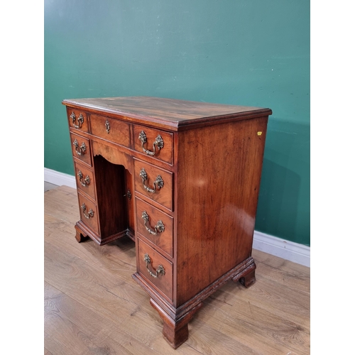 388 - A Georgian mahogany kneehole Desk with moulded top above seven drawers and recessed cupboard raised ... 