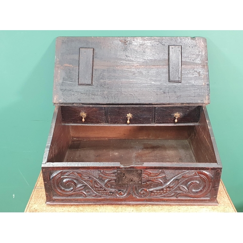 399 - An early oak slope top Bible/Desk Box, the moulded lift up lid enclosing three fitted drawers, the f... 