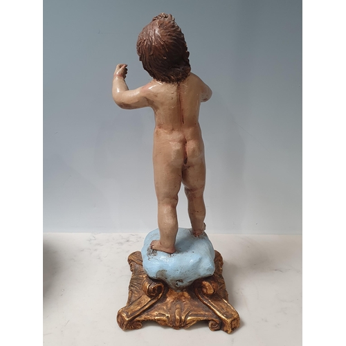 456 - A clay polychrome Figure of a Putti on square scroll base in the Rococo manner 12 1/4in H