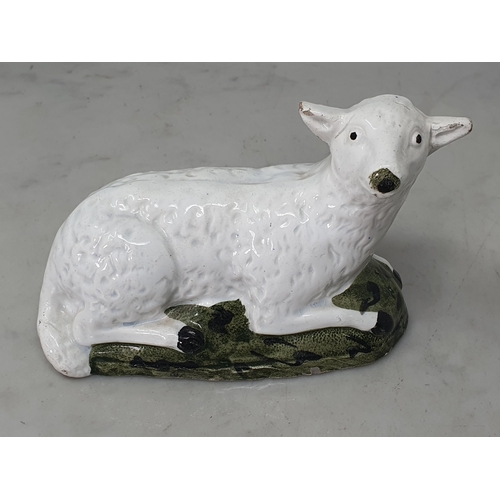 463 - An early 19th Century Staffordshire pearlware recumbent Ewe on mottled green shaped hollow base, A/F... 