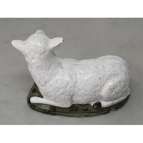 463 - An early 19th Century Staffordshire pearlware recumbent Ewe on mottled green shaped hollow base, A/F... 